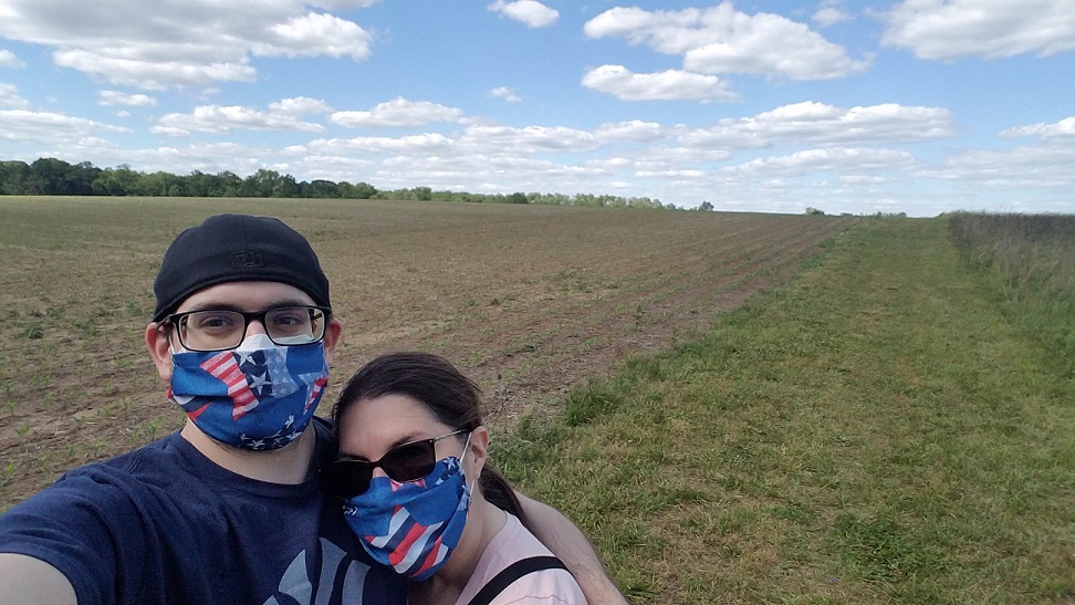 In crop field while wearing mask.